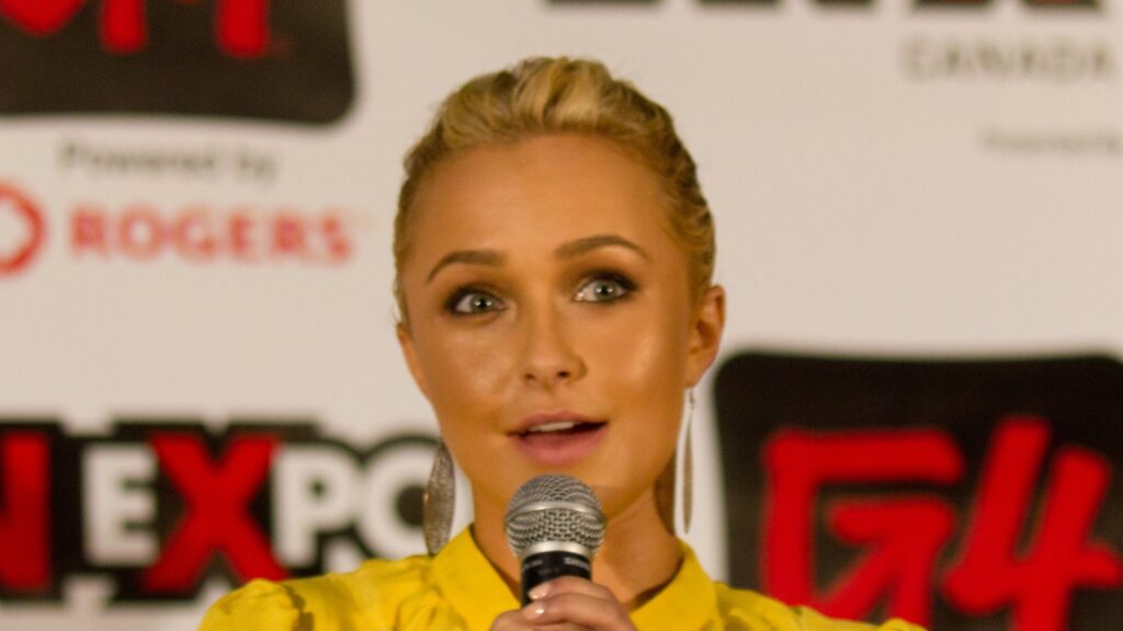 Hayden Panettiere berbicara di depan mikrofon dalam sebuah panel pada 2011