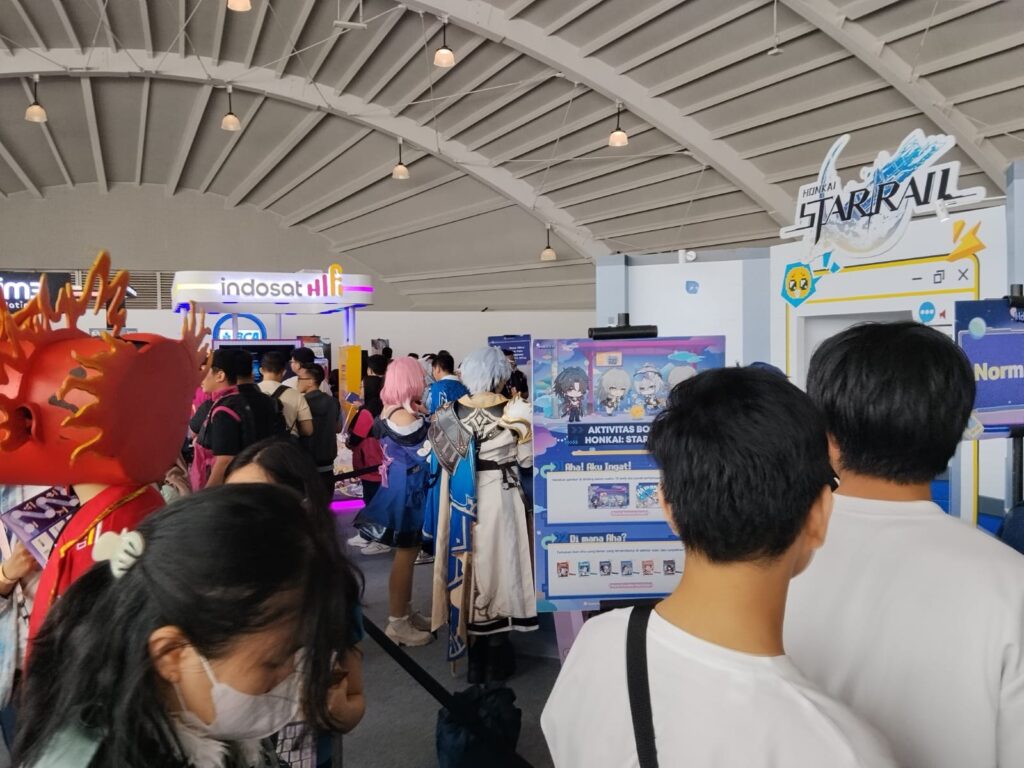 Area Honkai: Star Rail dengan papan aktivitas dan pengunjung bercosplay
